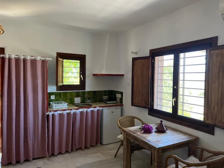 Una cocina con mesa y sillas y una ventana.