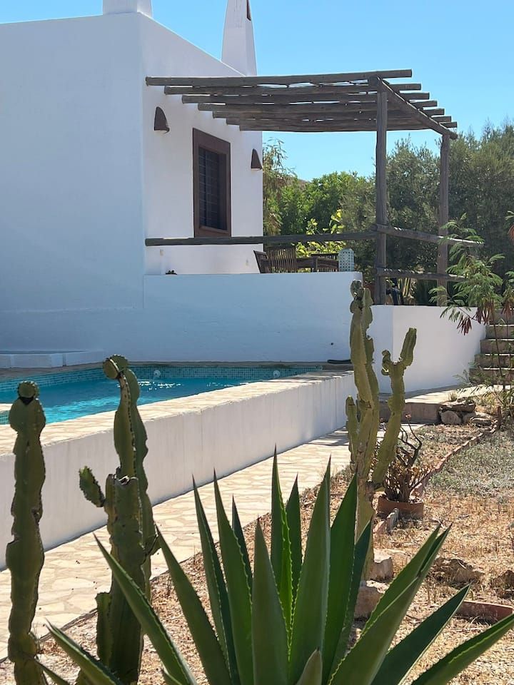 Una casa blanca con una piscina delante de ella