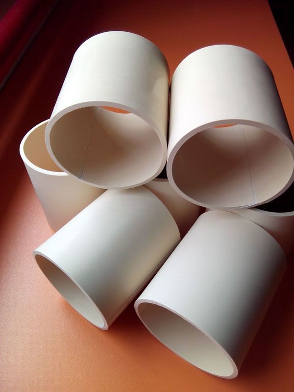 Un montón de tubos de plástico blanco están apilados uno encima del otro.
