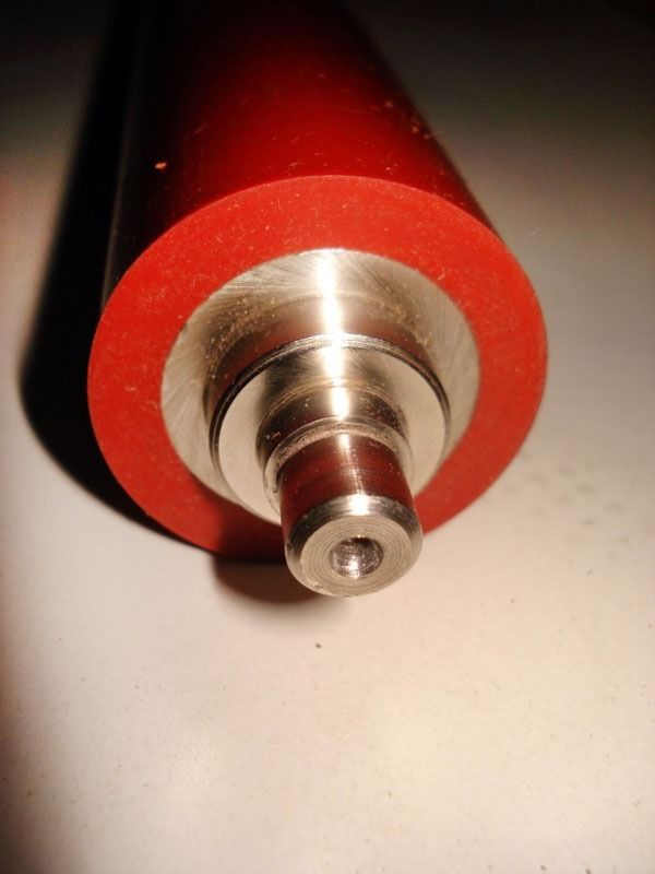 Un primer plano de un rodillo de goma rojo con un extremo de metal.