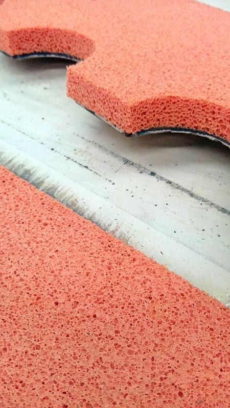 Un primer plano de un trozo de espuma roja en una cinta transportadora.