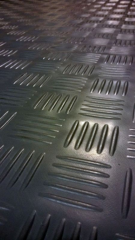 Un primer plano de una superficie metálica con un patrón a cuadros.