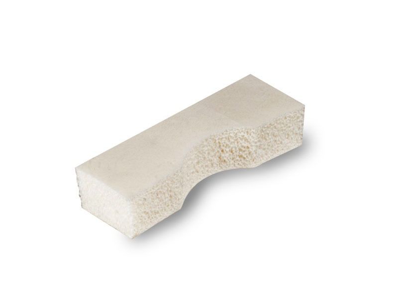 Un trozo de espuma blanca reposa sobre una superficie blanca.