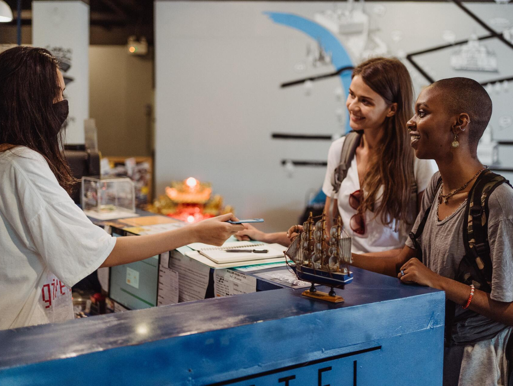 Drei Frauen stehen an einem Tresen in einem Hotel.
