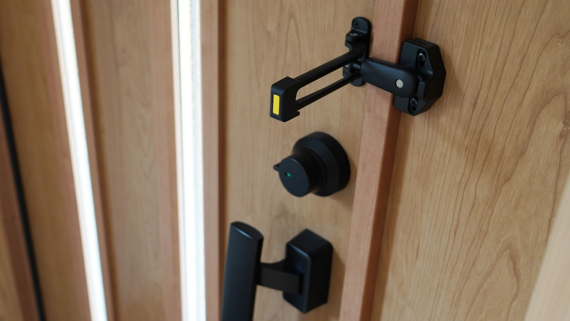 Porte en bois avec poignée noire, verrou de sécurité et loquet de sécurité.