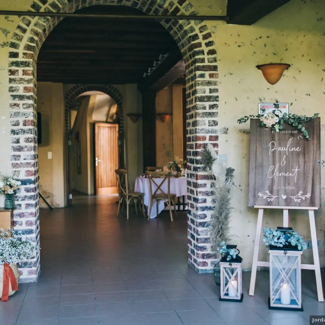 Une arche en briques mène à une réception de mariage.