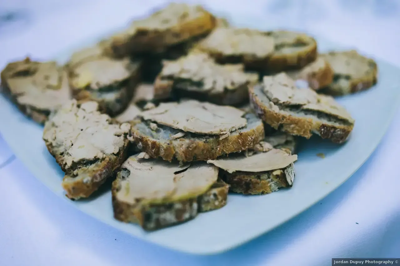 Assiette de tranches de pain grillées garnies d'une tartinade brun clair.