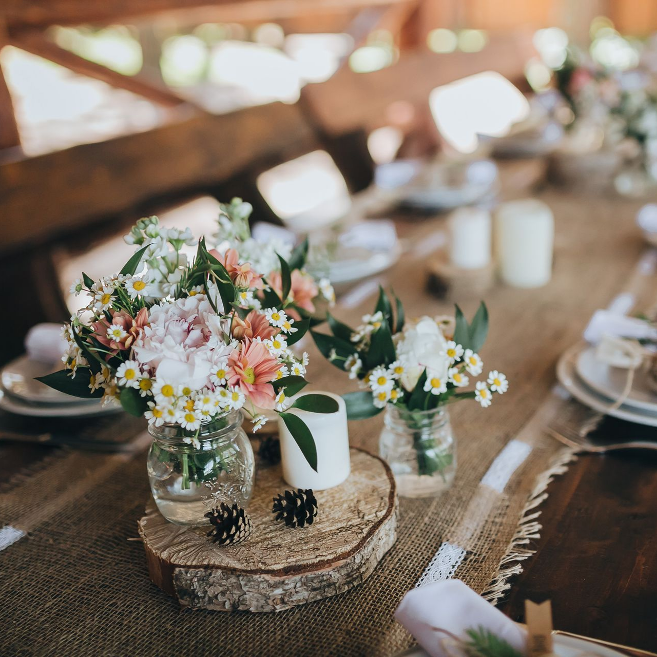 Décoration de table avec centres de table floraux, bougies et décoration rustique.