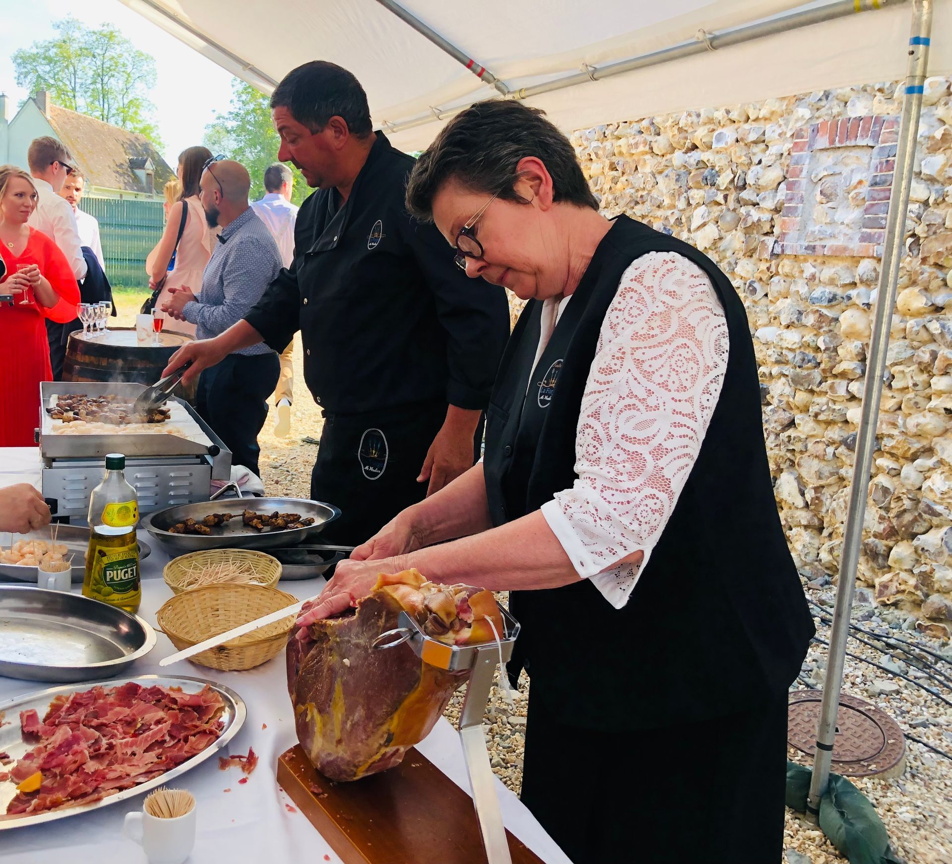 Une femme coupe de la viande à une table de buffet.