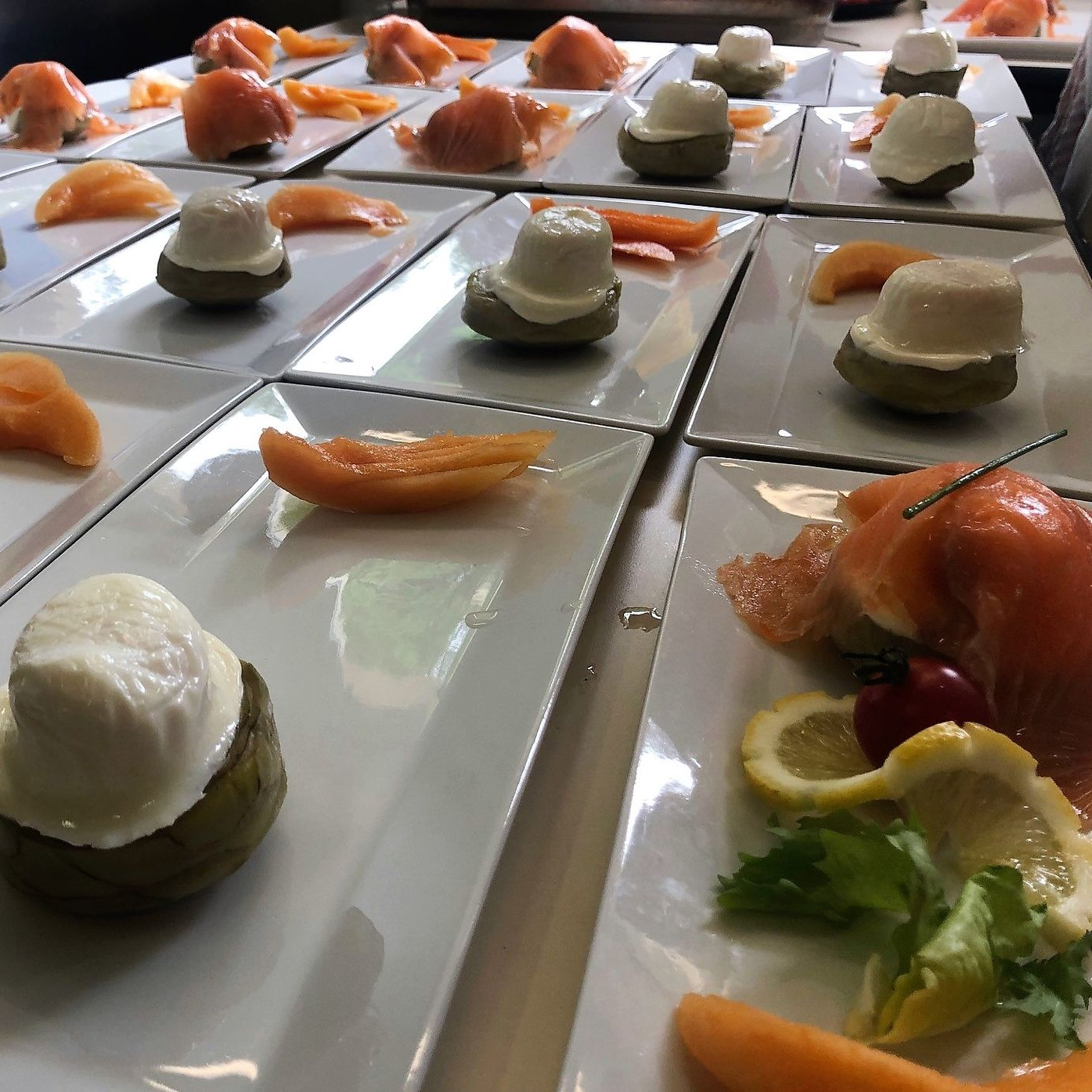 Assiettes d'entrées : saumon, melon, cœurs d'artichauts au fromage blanc. Cadre de restaurant.