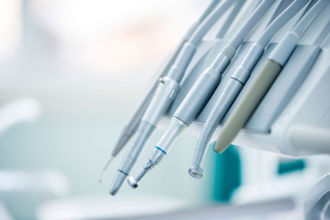 Herramientas dentales, varios instrumentos de plata, colgados en una clínica dental, primer plano.