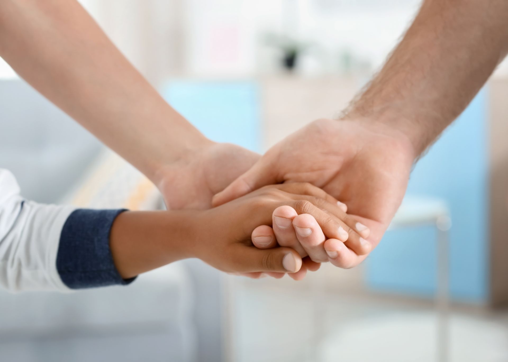Photo des mains de deux adultes et d'un enfant