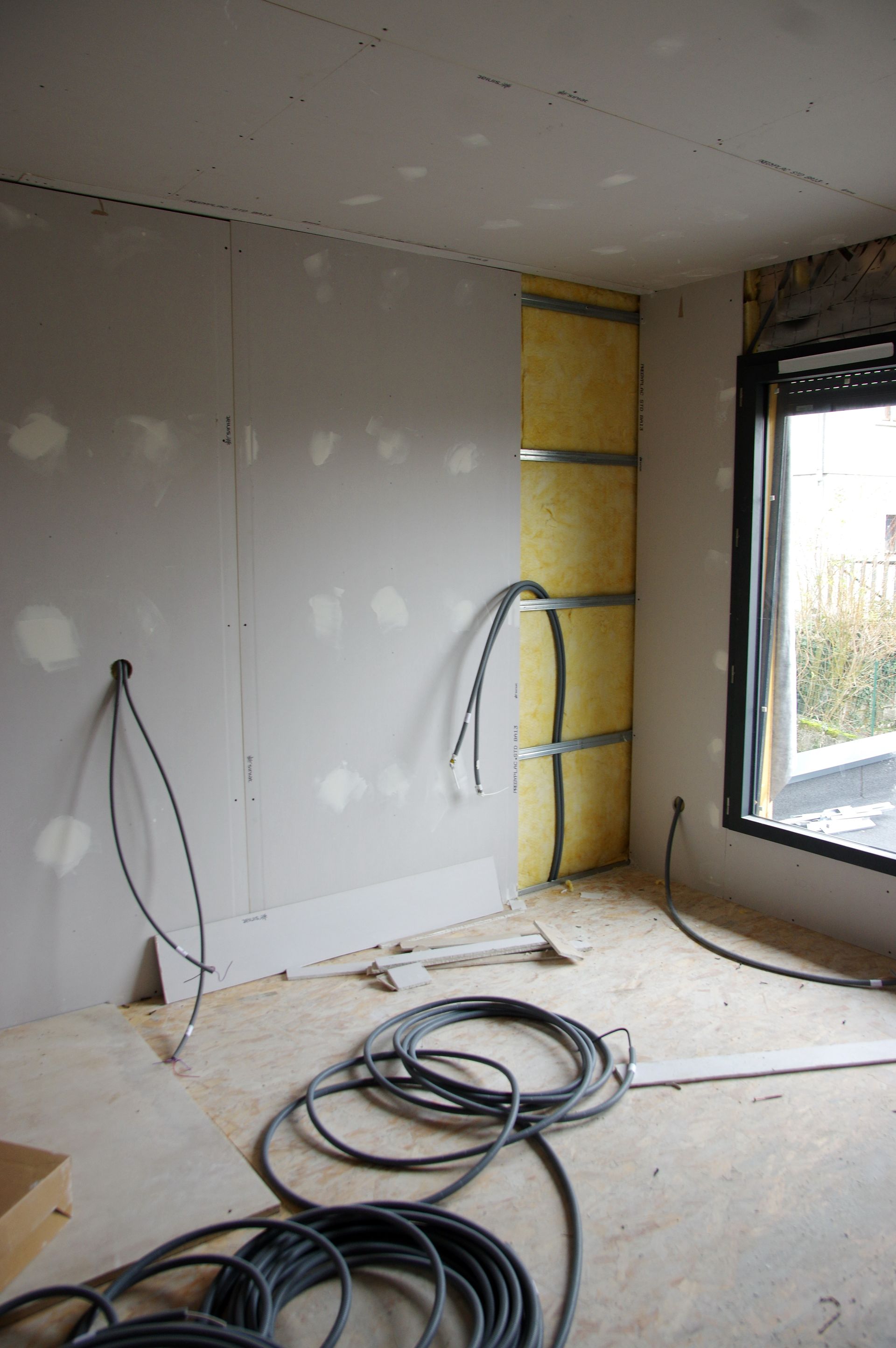 Vue grand angle d'un grenier non aménagé avec des chevrons en bois.