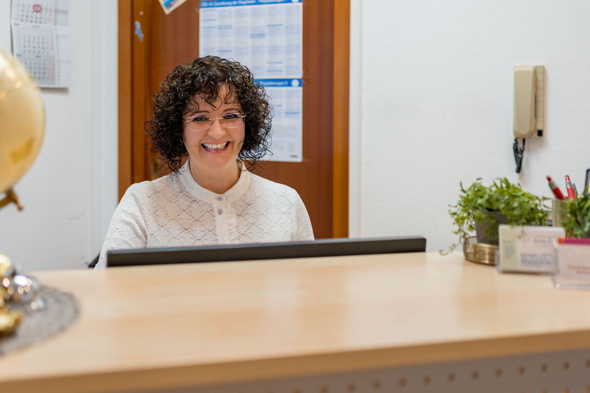 Frau und Mädchen üben Sprachtherapie und gestikulieren dabei mit den Händen, drinnen.