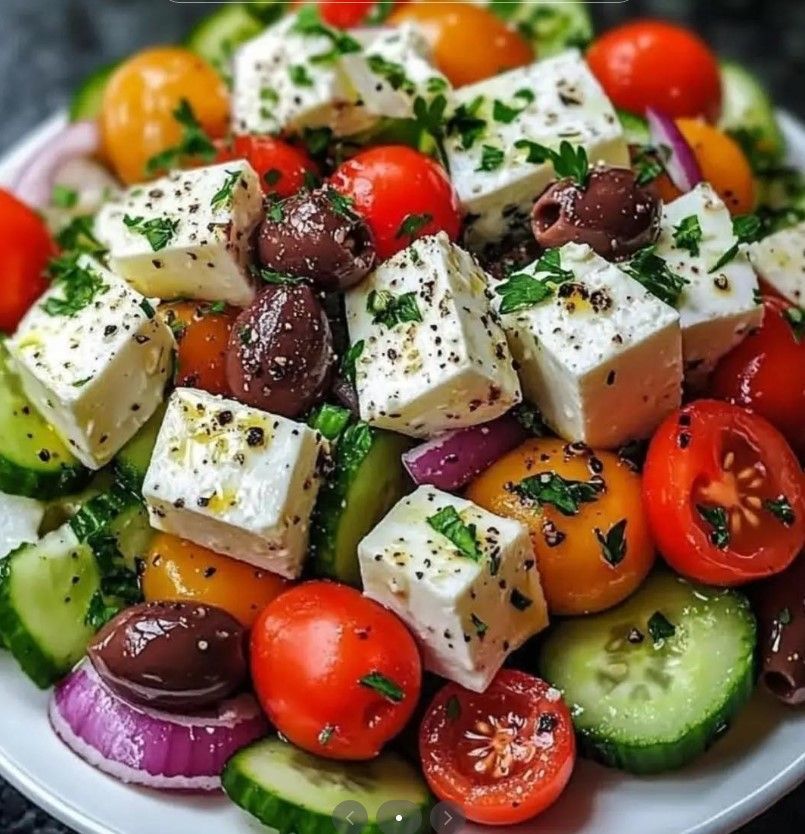 Ensalada griega con queso feta, tomates, pepinos, aceitunas y cebolla roja.
