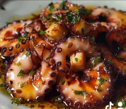 Pulpo a la plancha con patatas doradas y hierbas, en salsa.