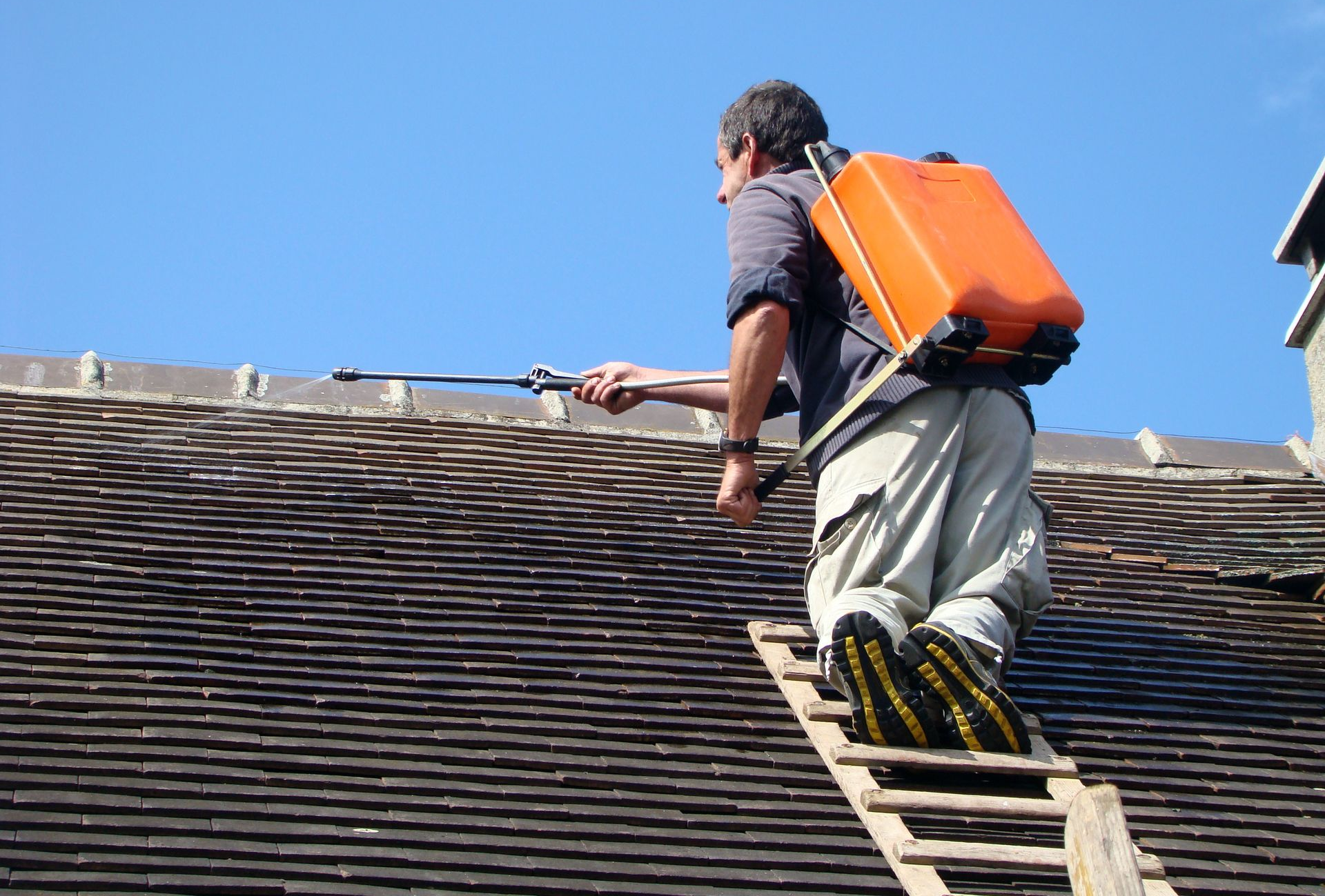 Un artisan en train d’émousser une toiture.