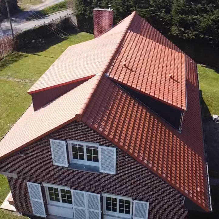 Une toiture en tuiles rouges, vue de haut.