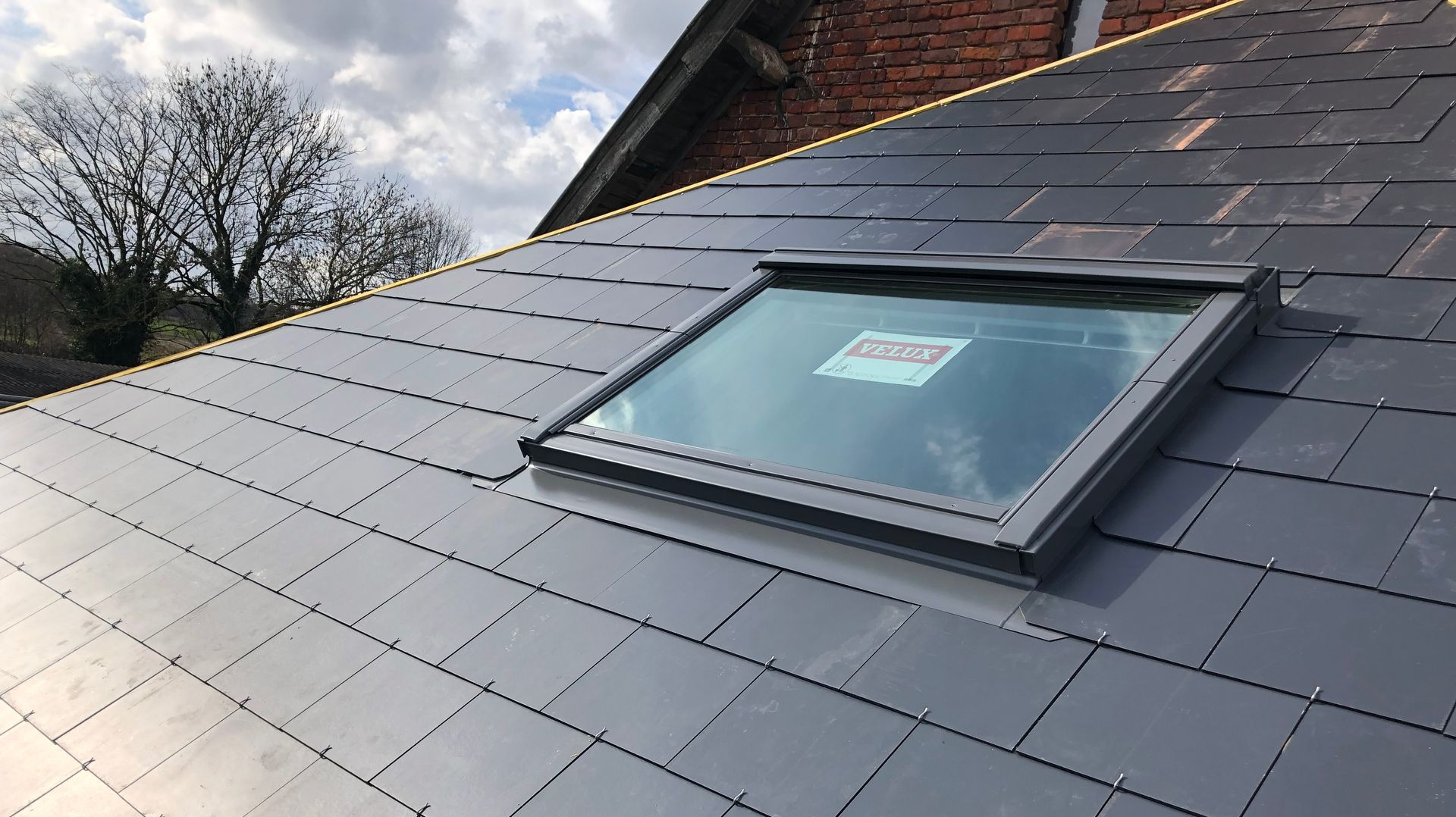 Nouvelle fenêtre Velux installée sur un toit.