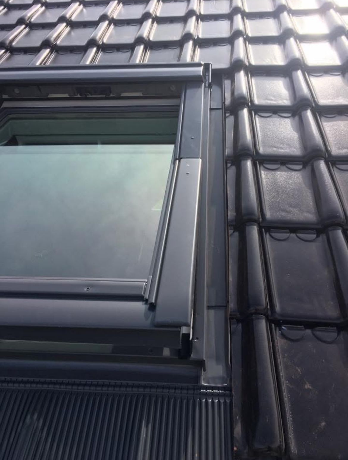 Une toiture avec couverture neuve et fenêtre de toit.