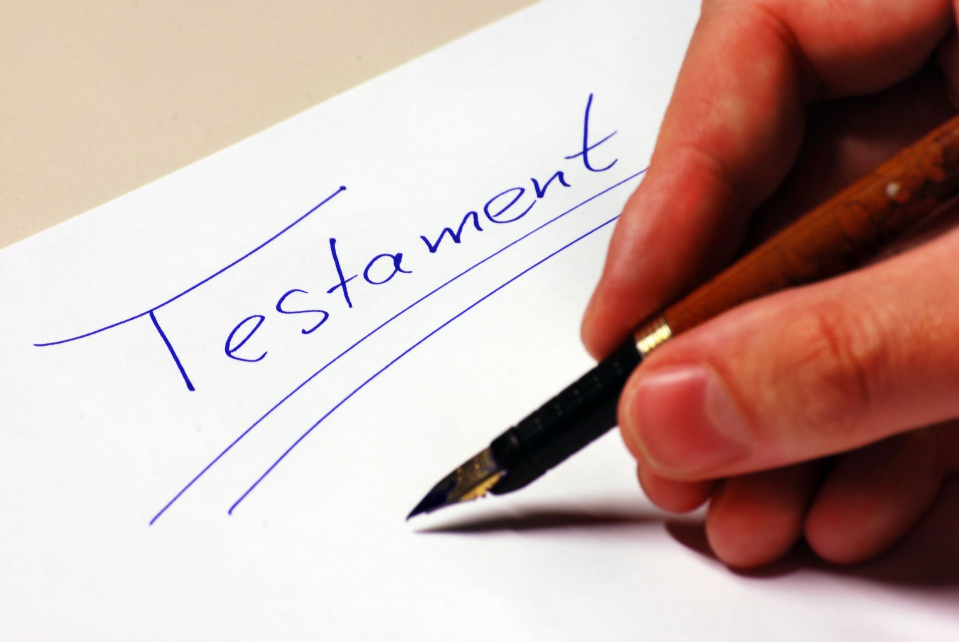 Écriture manuscrite du mot Testament sur une feuille de papier.