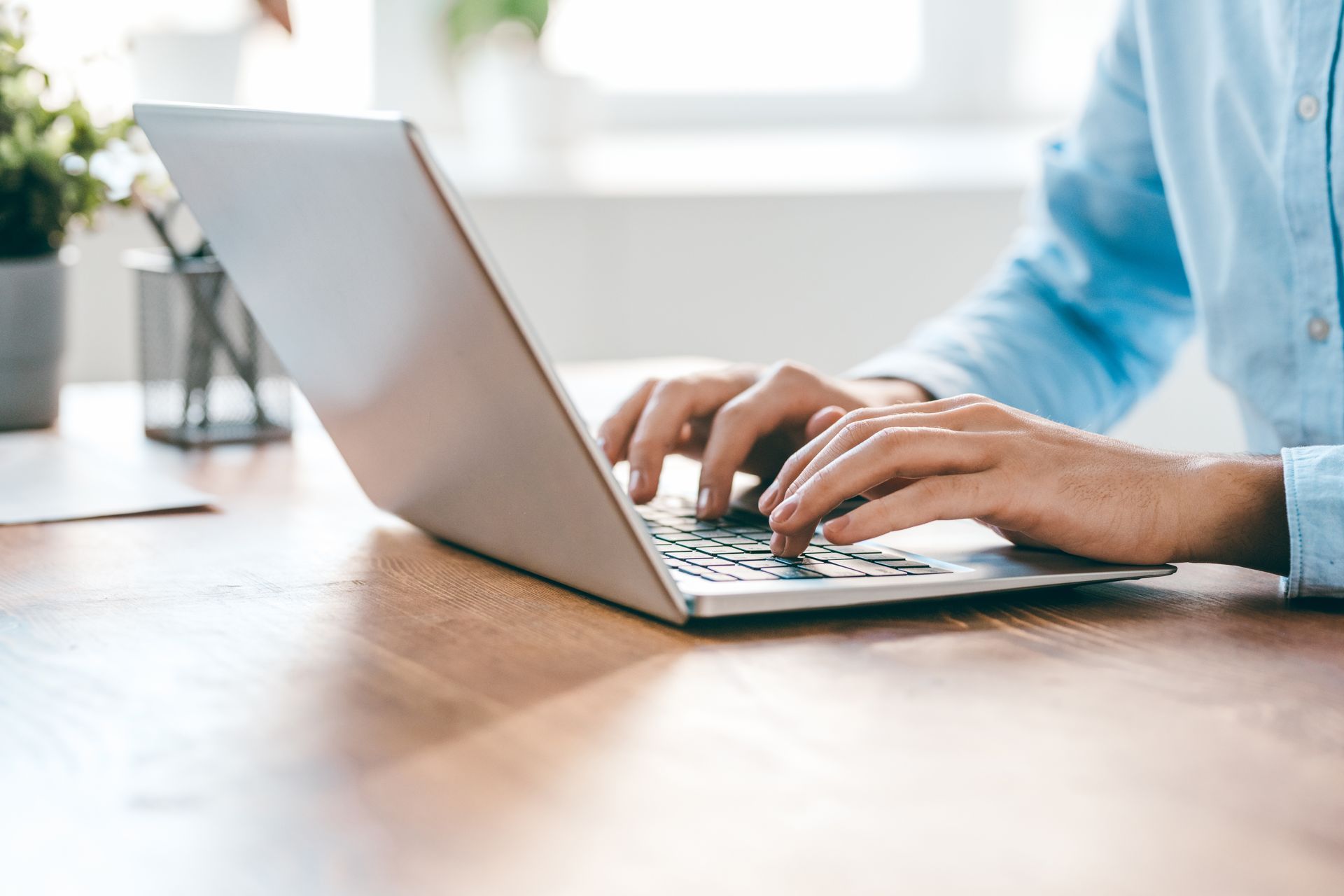 Une personne tape sur un ordinateur portable à un bureau.