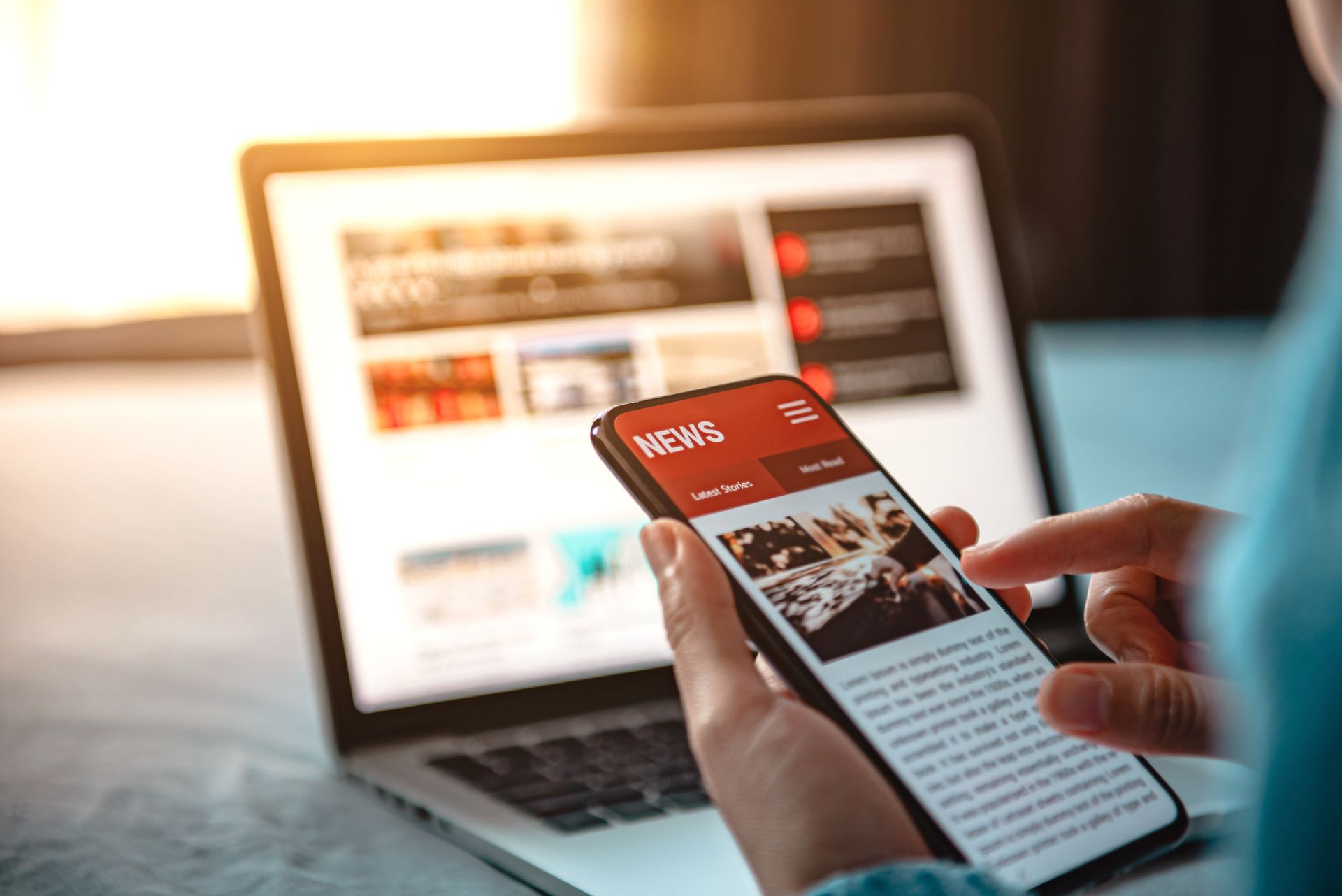 Un smartphone à côté d'un ordinateur portable affichant un site web sur un bureau.