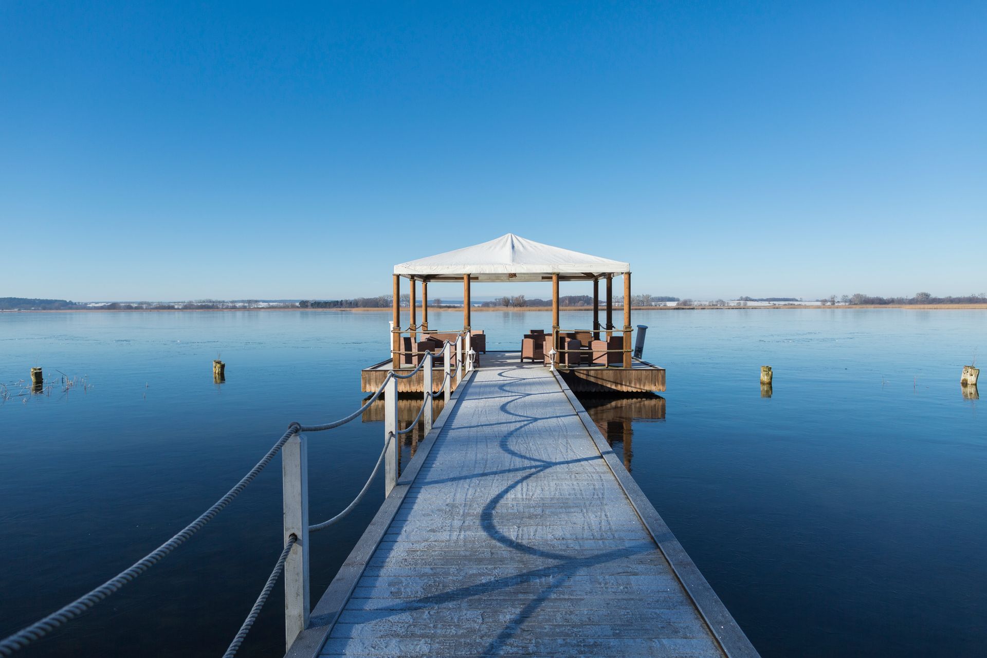Ein Dock mit einem Pavillon darauf inmitten eines Sees.