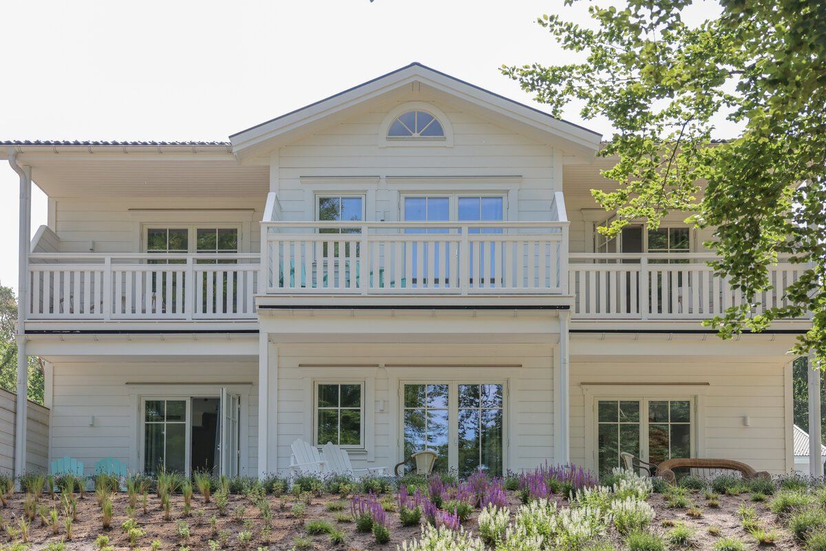Ein großes weißes Haus mit Balkon und vielen Fenstern.