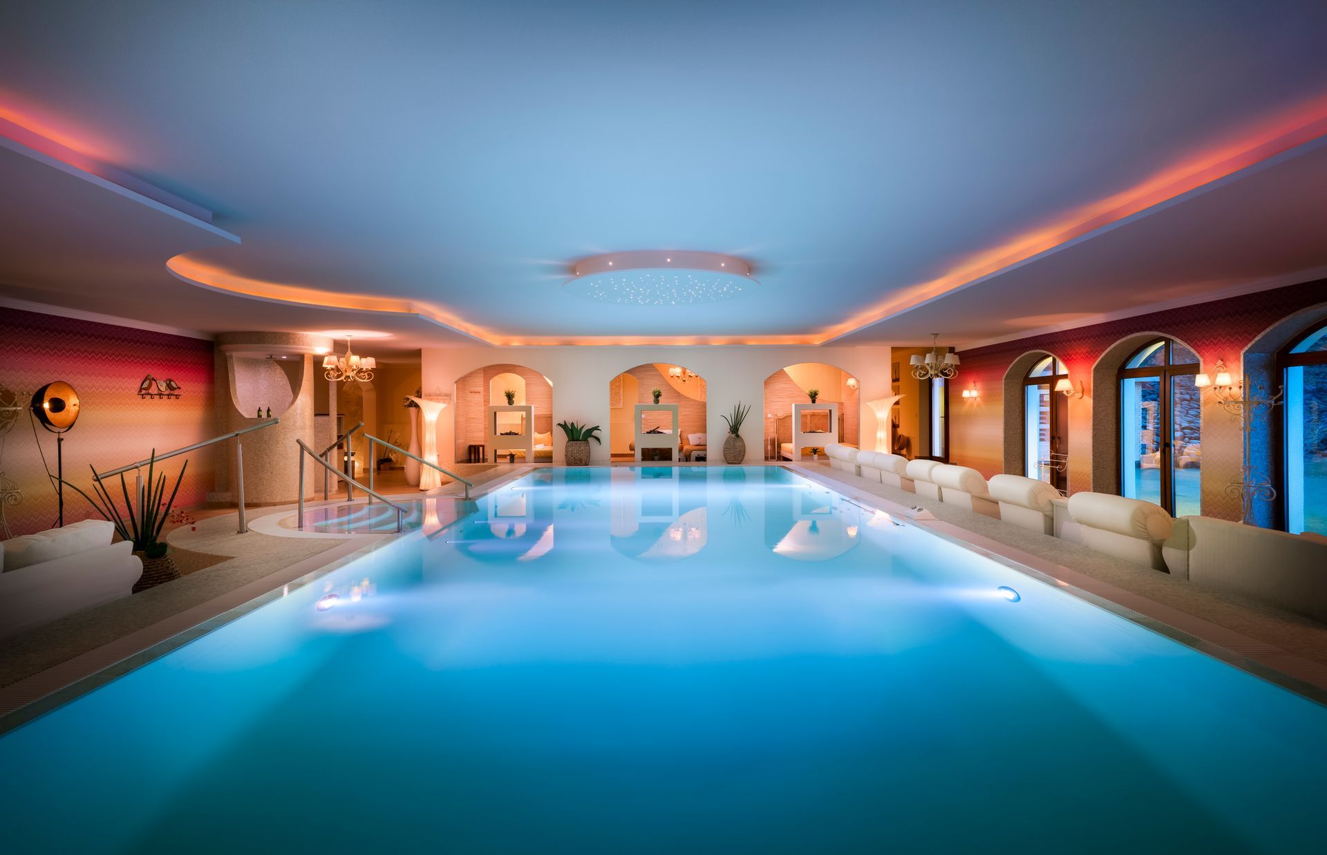 Ein großes Hallenbad mit Treppe zum Pool.