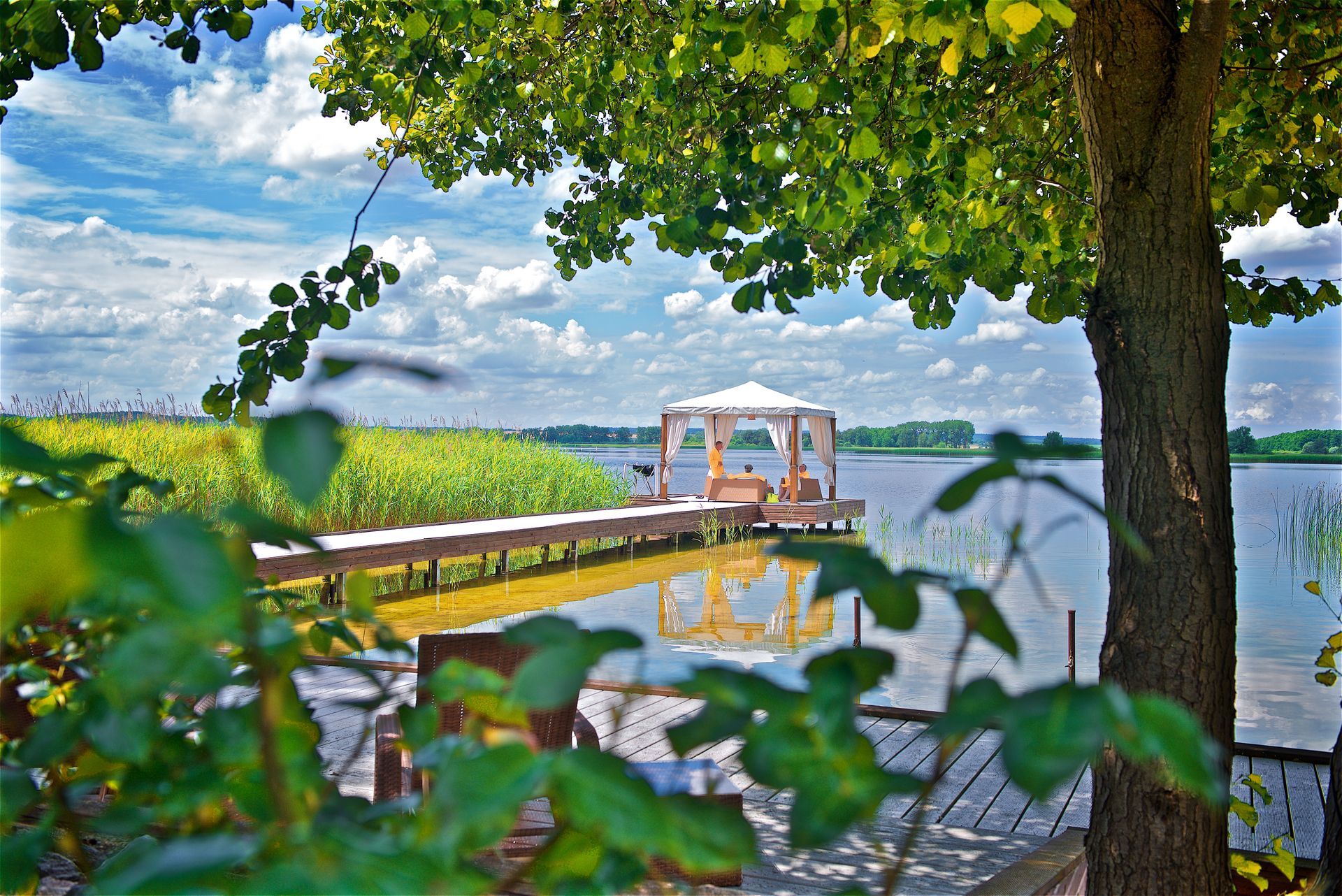 Ein Dock mit einem Pavillon darauf und Blick auf einen See.