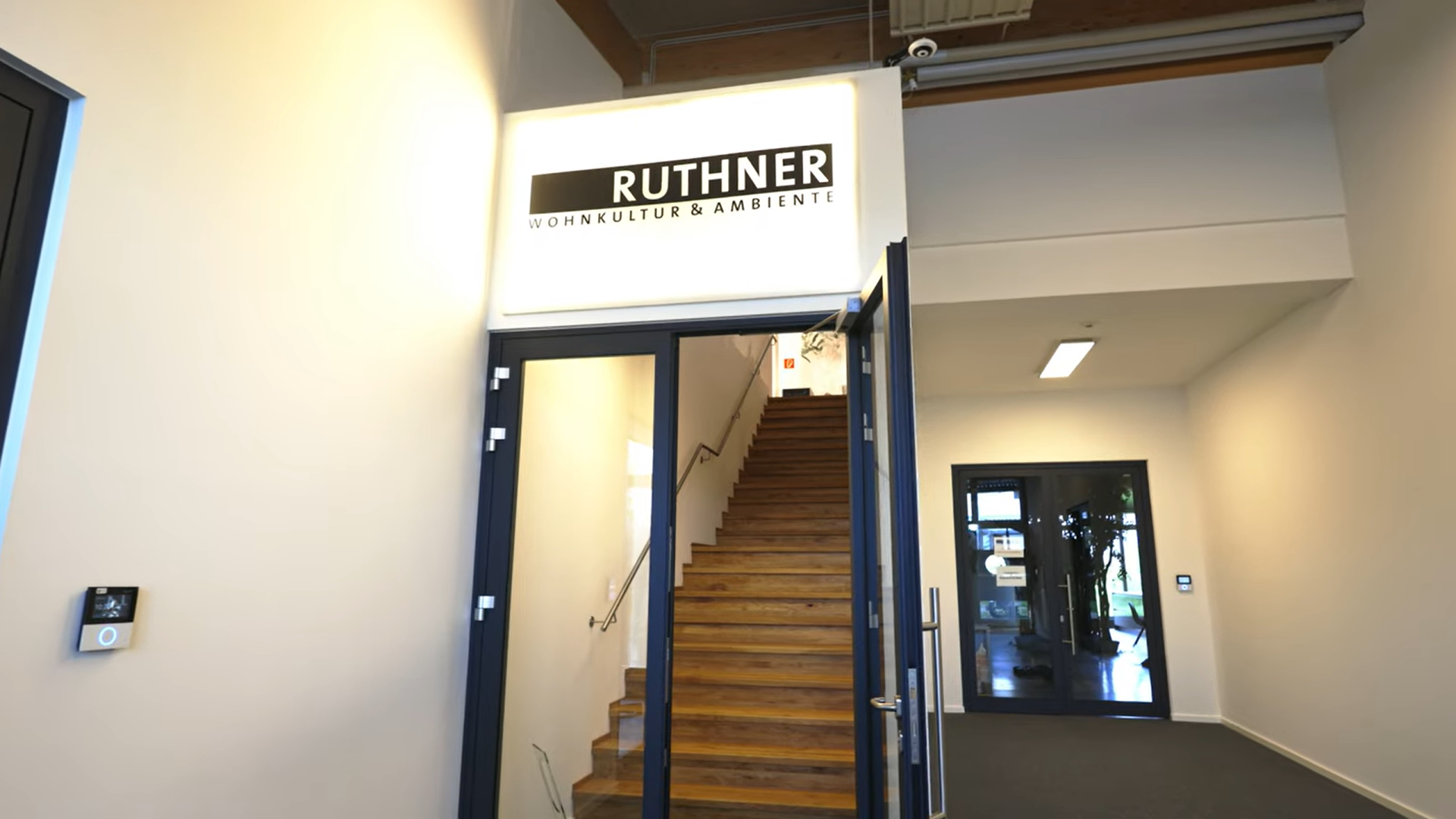 Eingang zu einem Treppenhaus mit einem RUTHNER-Schild über dem Türrahmen und einem Flur auf der rechten Seite.