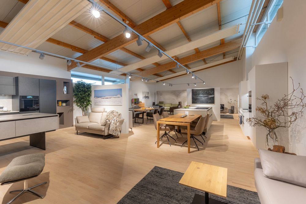 Helles, modernes Wohnzimmer mit sichtbaren Holzbalken, Holzböden und neutralen Möbeln.