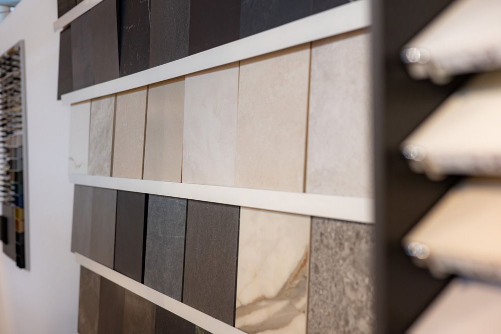 Musterfliesen an einer Ausstellungswand in neutralen Beige-, Grau- und Steintönen