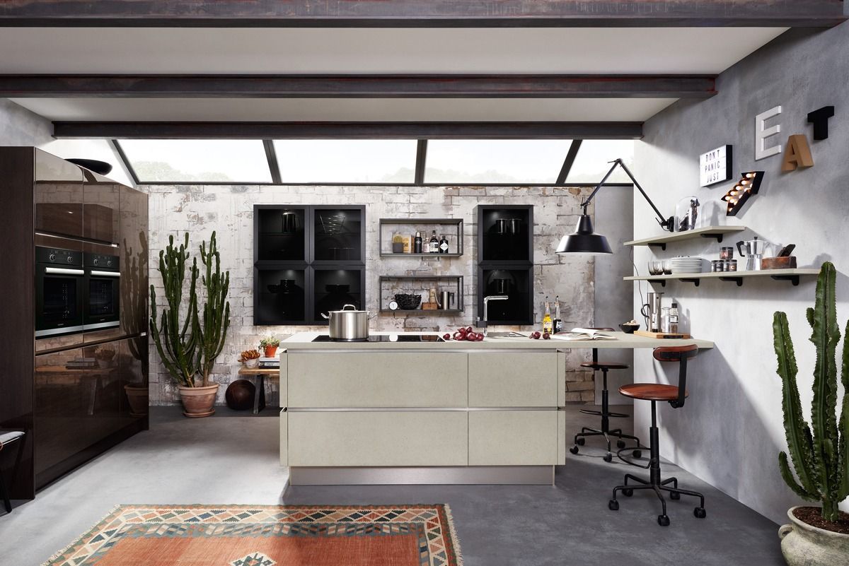 Moderne Küche mit Kochinsel, Oberlichtdecke, Barhocker und Regalen vor einer grauen Wand