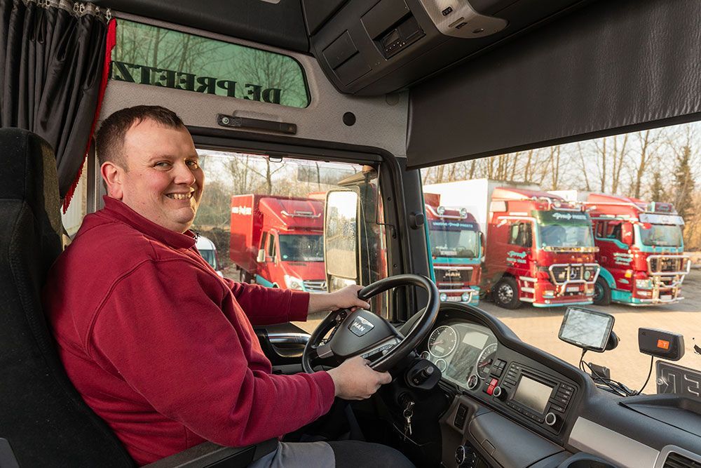 Ein Mann sitzt auf dem Fahrersitz eines Lastwagens.