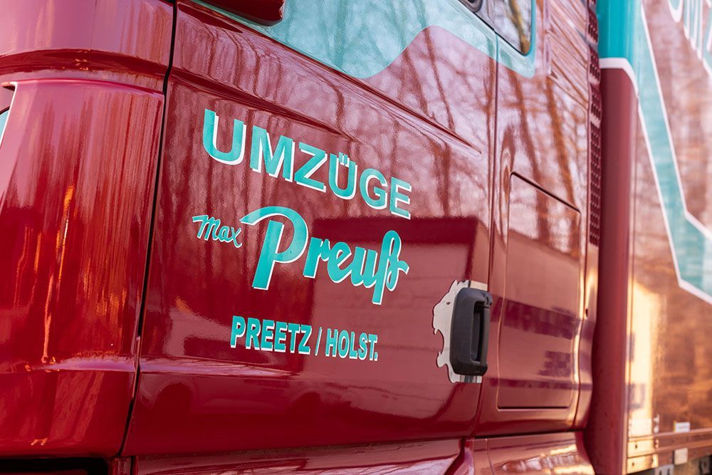 Ein roter LKW mit dem Wort „Umzuge“ auf der Seite