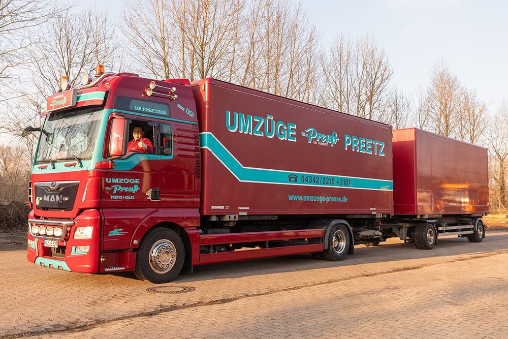 Ein roter Lastwagen steht am Straßenrand.