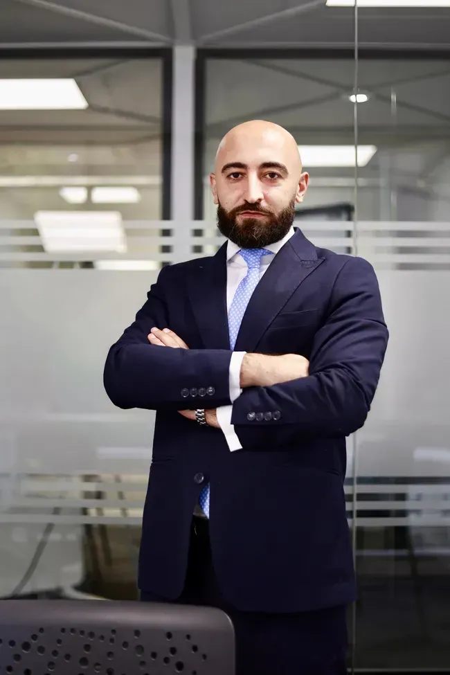 Dos hombres vestidos de negocios revisan papeles en una mesa en una oficina.