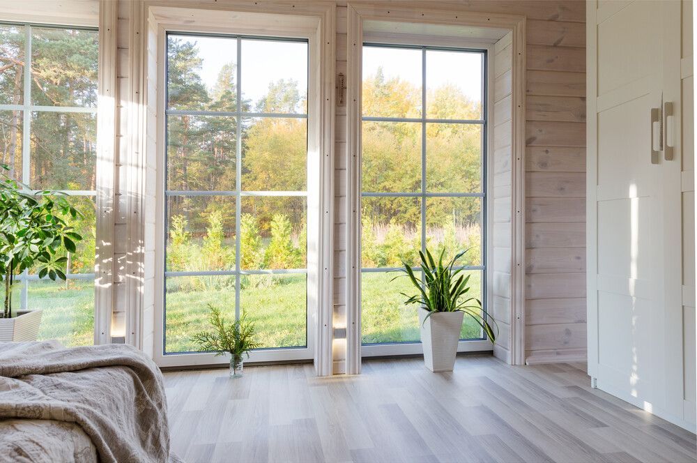 Un dormitorio con muchas ventanas y una cama.