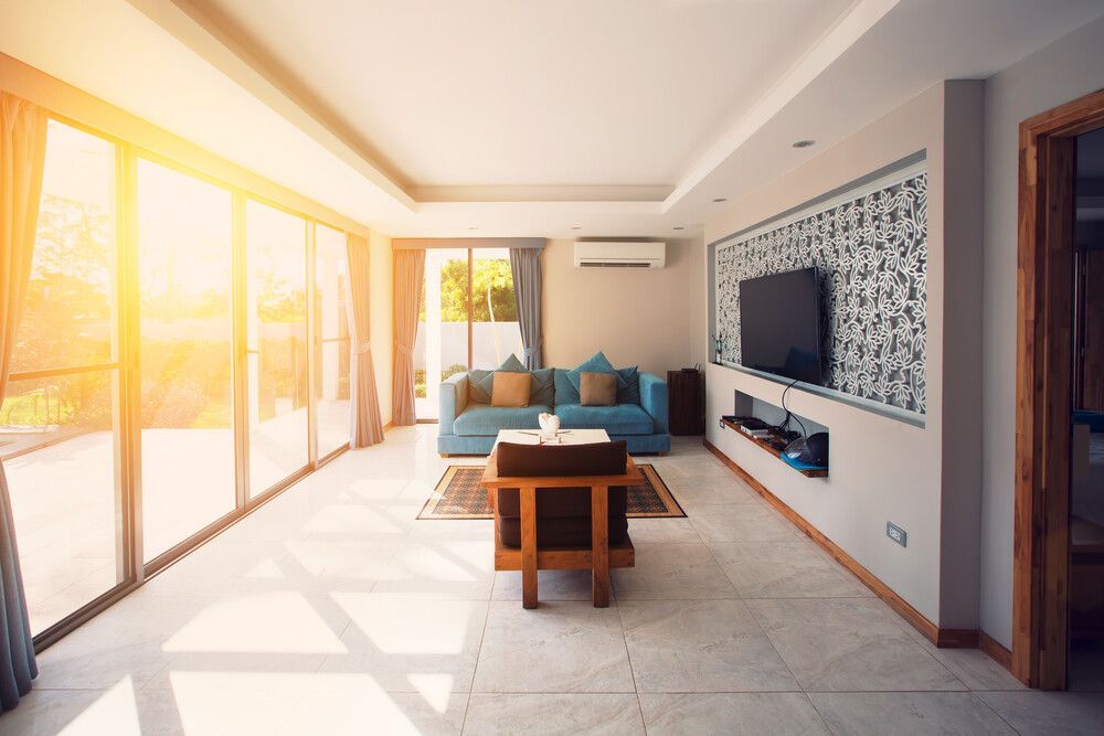 Una sala de estar con sofá, silla, mesa y televisión.
