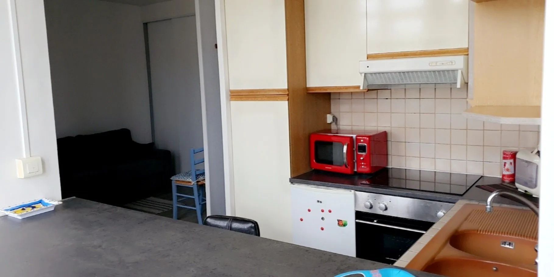 Cuisinette, coin repas avec micro-ondes rouge