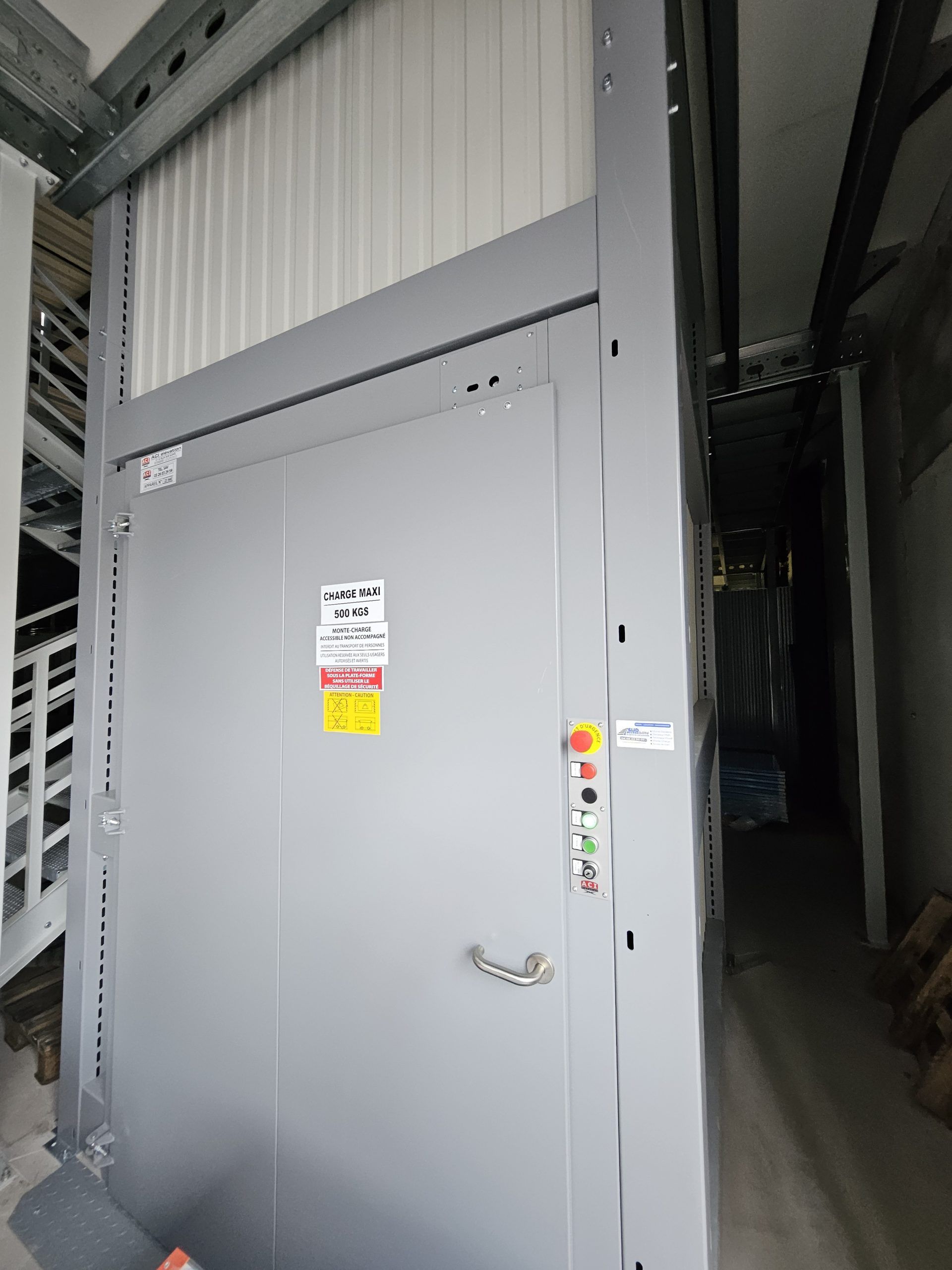 Armoire électrique industrielle grise avec étiquettes d'avertissement dans un couloir d'entrepôt