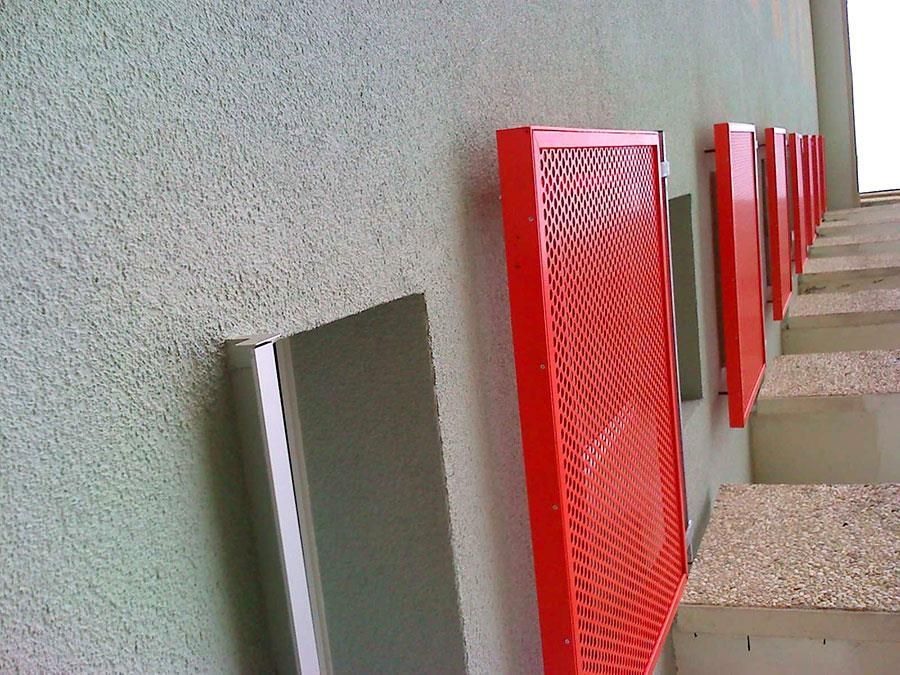 Eine Reihe roter Kästen an einer grünen Wand