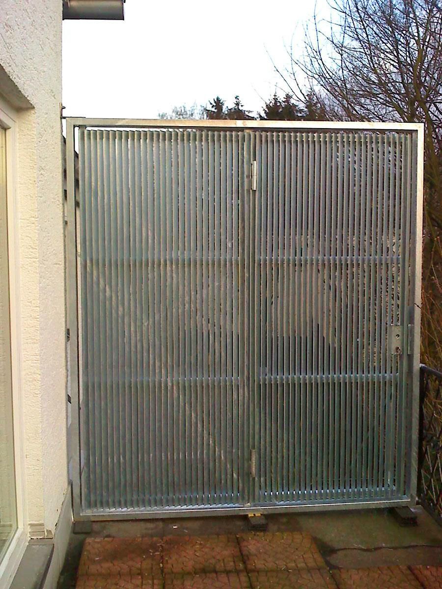 An der Seite eines Gebäudes befindet sich ein Metalltor