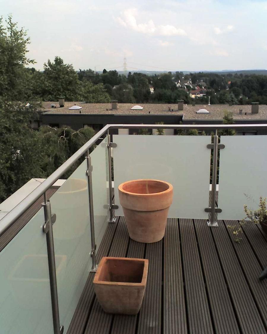 Ein Balkon mit Glasgeländer und Topfpflanzen