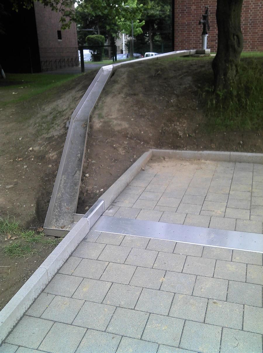 Ein gemauerter Gehweg mit einem Backsteingebäude im Hintergrund