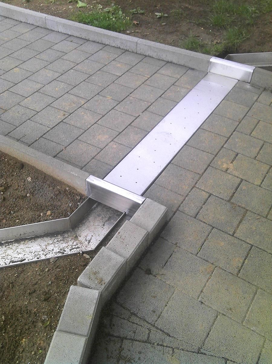 Ein Ziegelweg mit einer Metallbarriere zwischen den Ziegeln