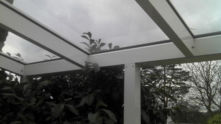 Ein Schwarzweißfoto einer Pergola mit Bäumen im Hintergrund