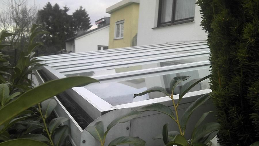 Ein weißes Gebäude mit Glasdach ist von Bäumen umgeben.